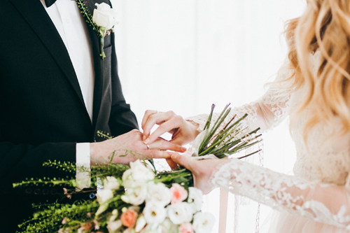 wedding Bride placing ring on groom's hand