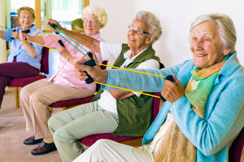 Group of older adult women stretching with exercise bands