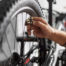 Hand repairing a bike wheel