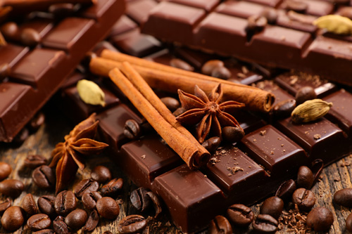 chocolate bar and spices on wood background