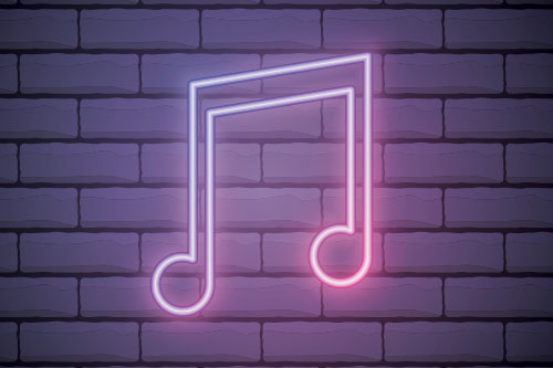 Neon music note on the brick wall