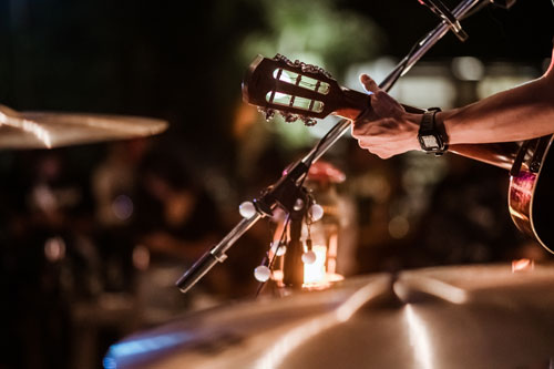 Person playing guitar in front of crowd