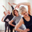 group of older adults stretching overhead