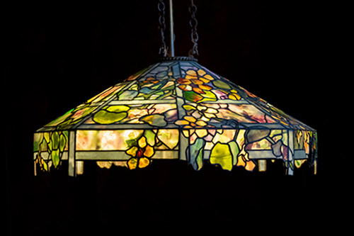 Colorful stained glass lamp hanging against a black background