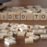 Scrabble tiles on a table spelling the word 'tour'