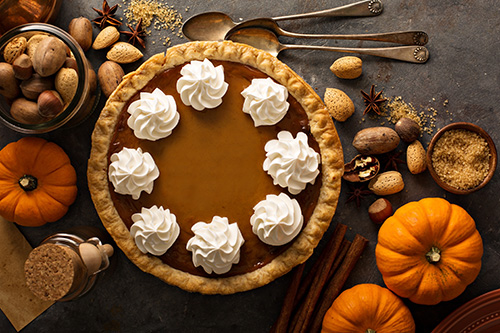 Thanksgiving pumpkin pie on table with pumpkin figures